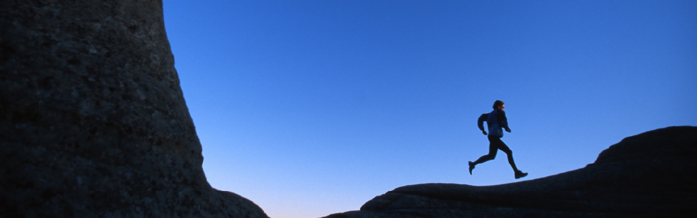 Runner moving through an open landscape at dusk to reflect the article's focus on mental strategies during long runs