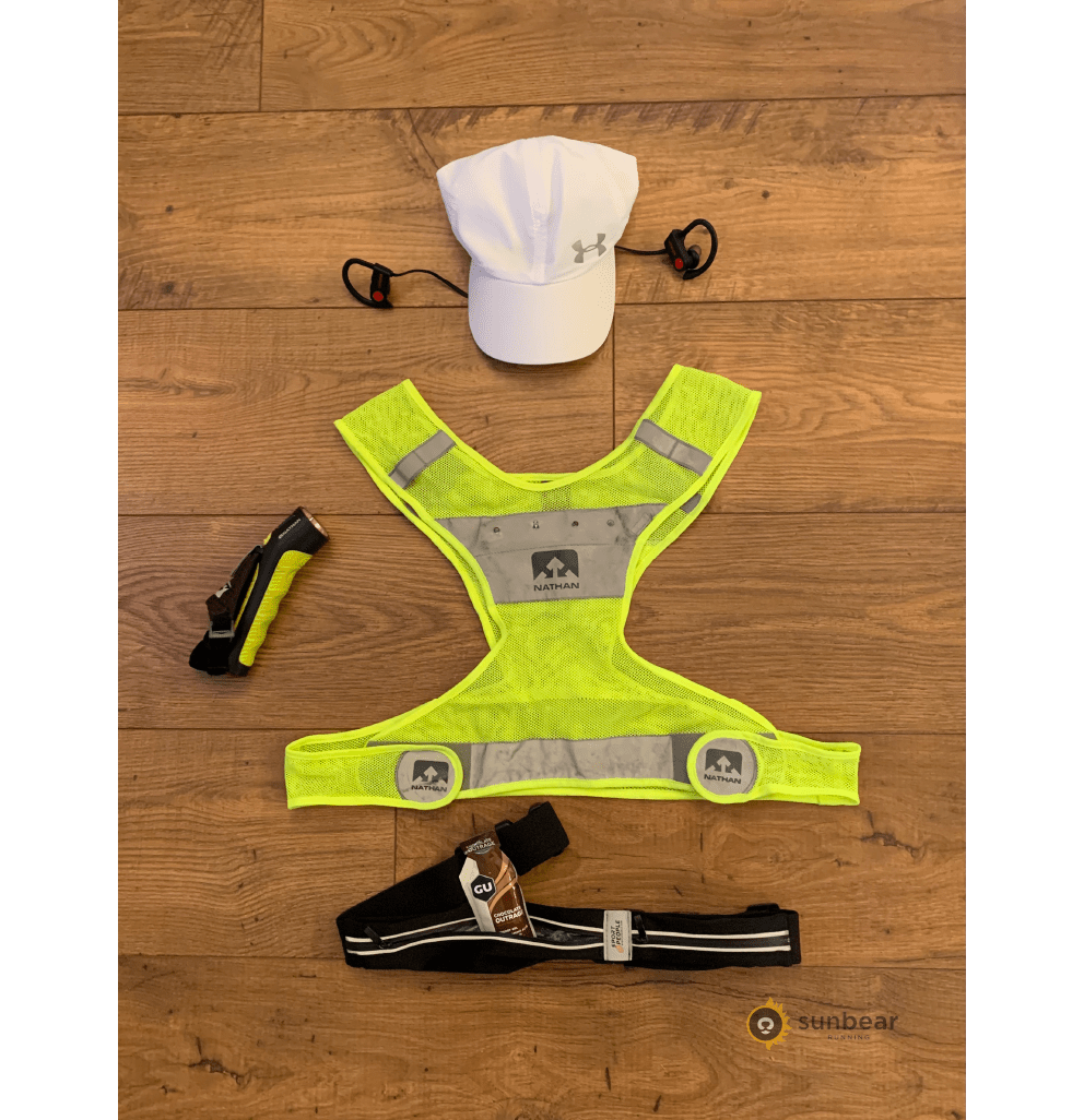 Rain-running accessories including a hat, headphones, vest, light, and waist pack for visibility and comfort